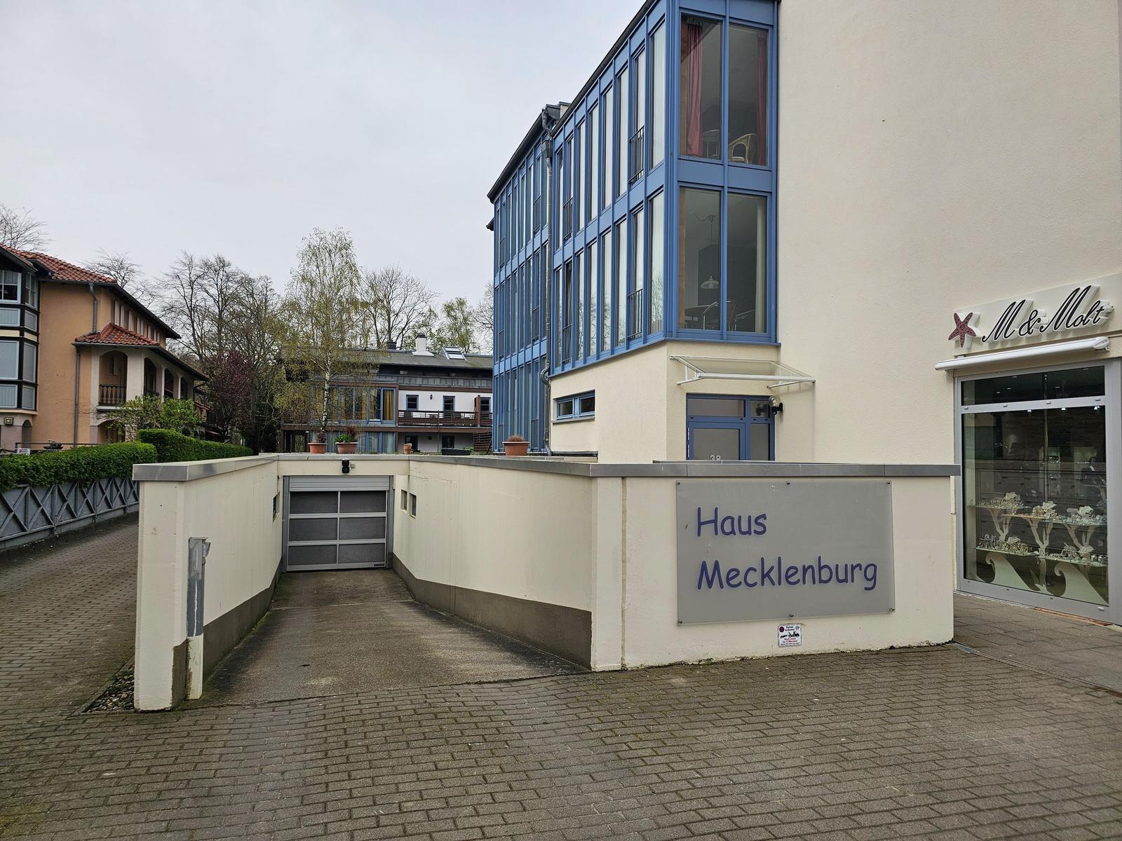 Haus Mecklenburg mit Garagentor und blauen Fenstern an der Straße