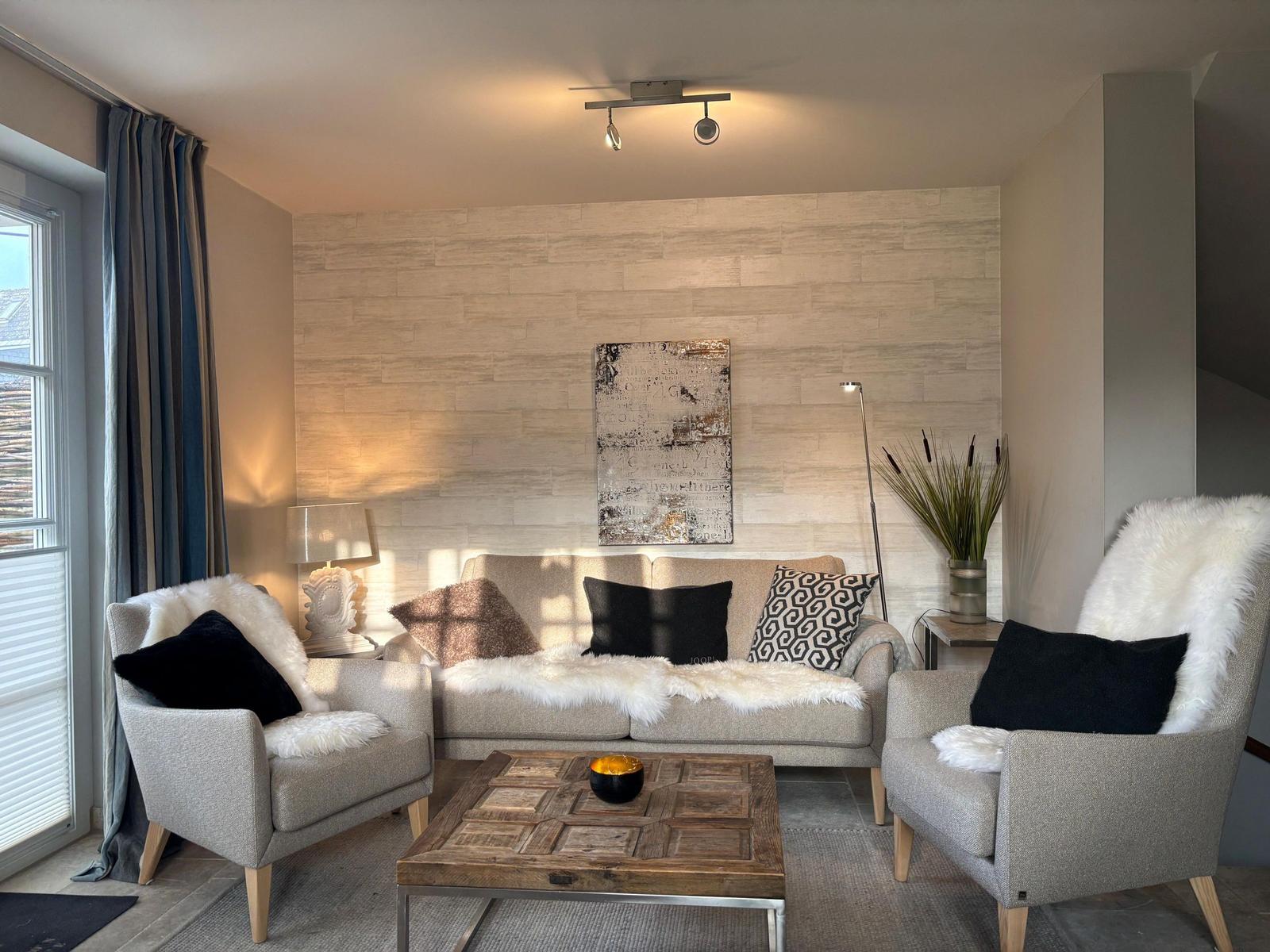 Living room with sofa, two armchairs, wooden table, and wall art.