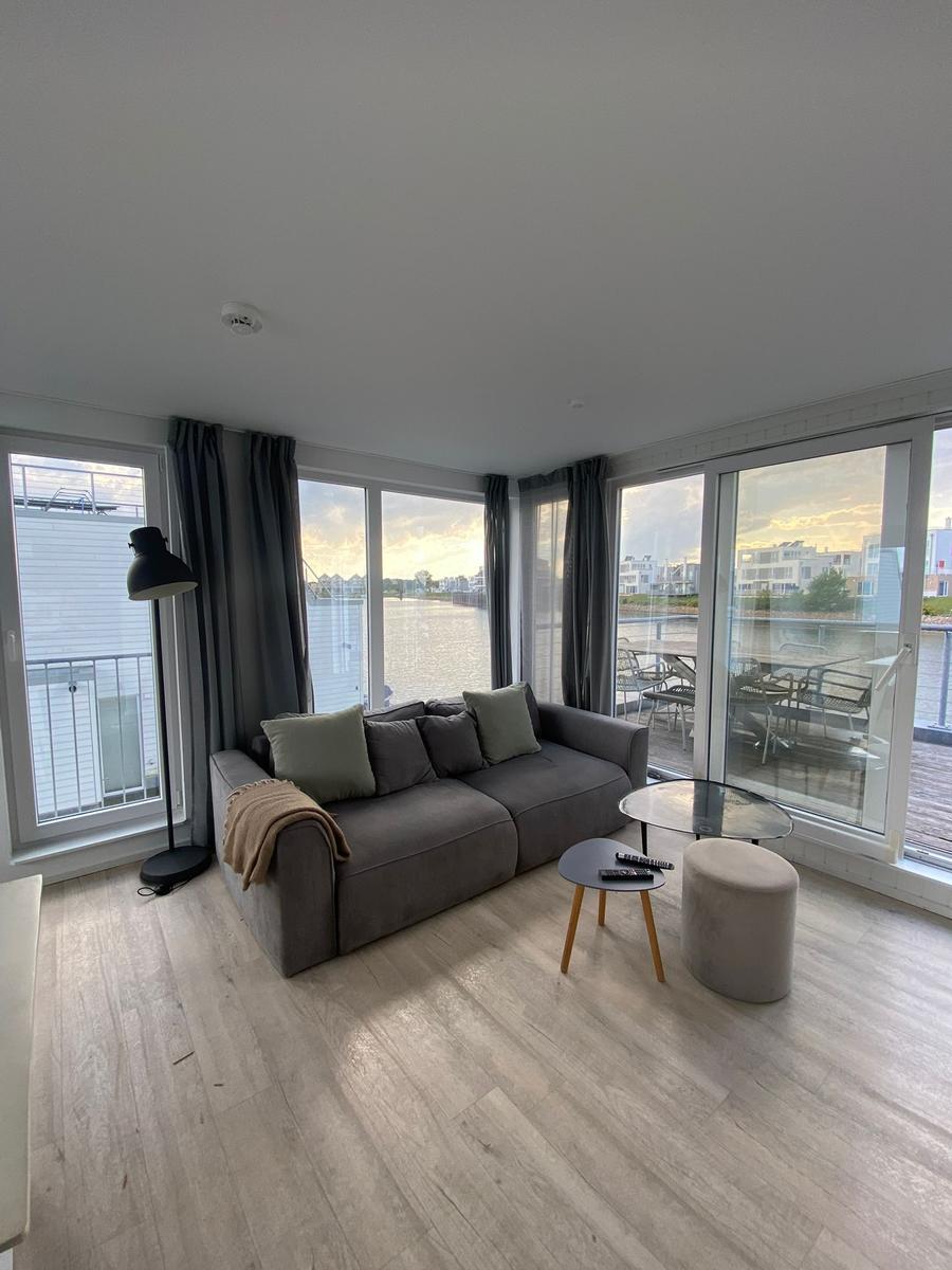 Living room with sofa, table, and water view