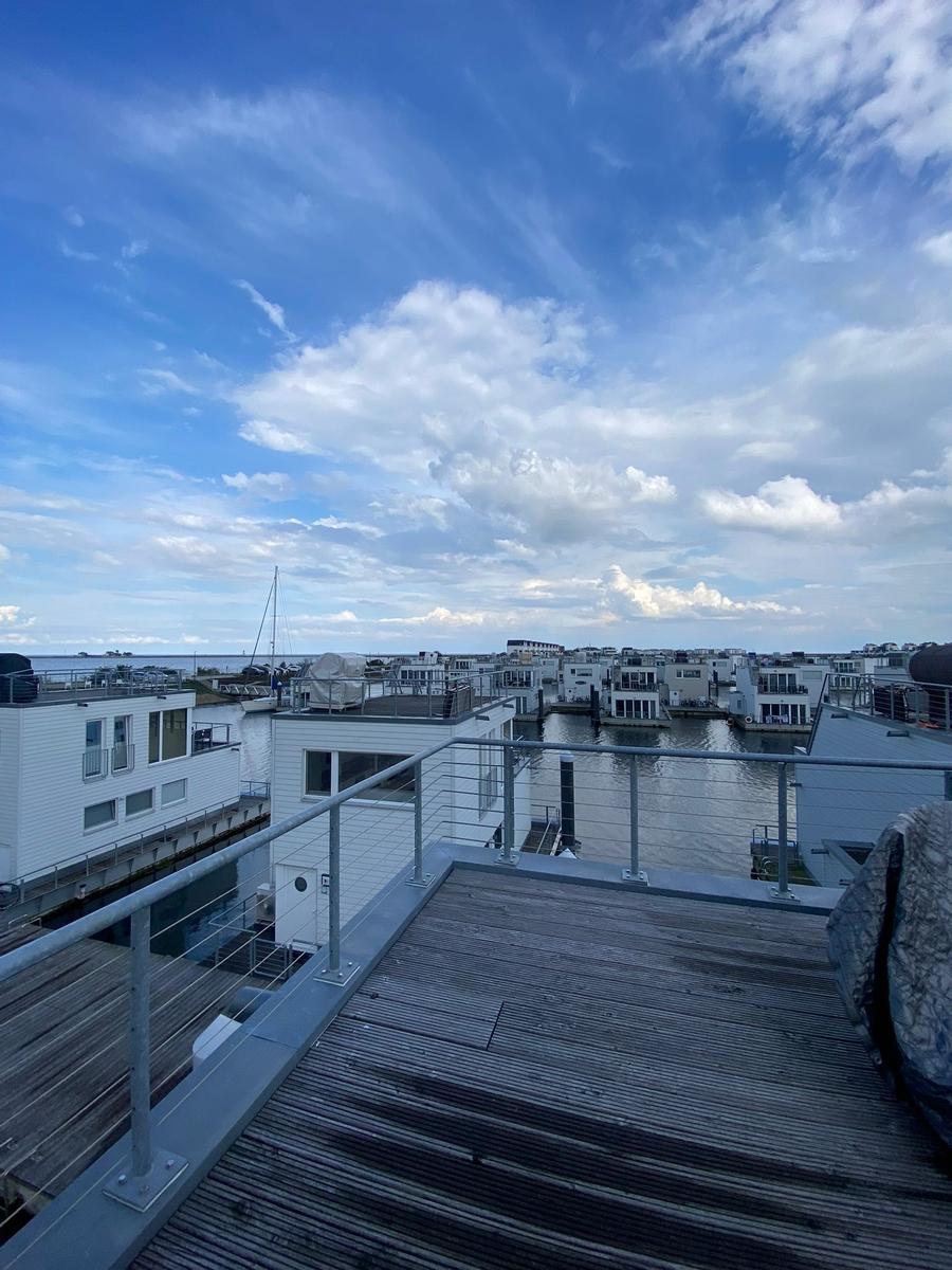 Deck with view of water and modern houses in the harbor.