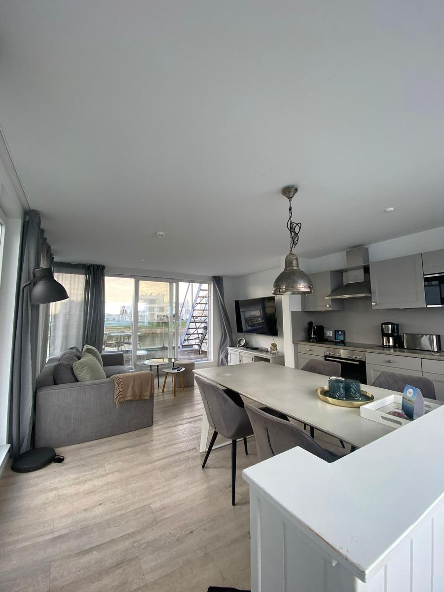 Living kitchen with dining area, sofa, and terrace view.
