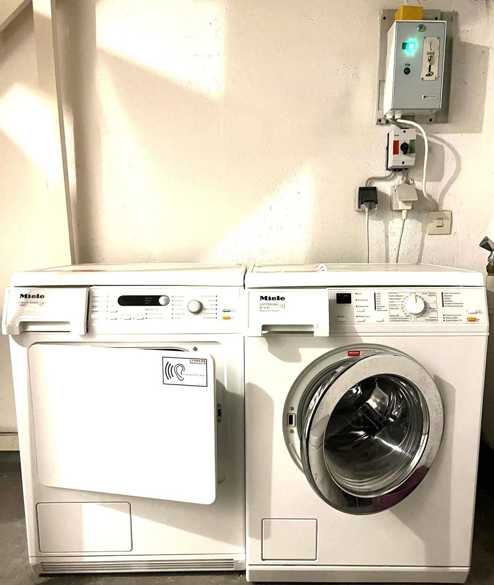 Waschmaschine und Trockner mit Münzeinwurf befinden sich im Keller