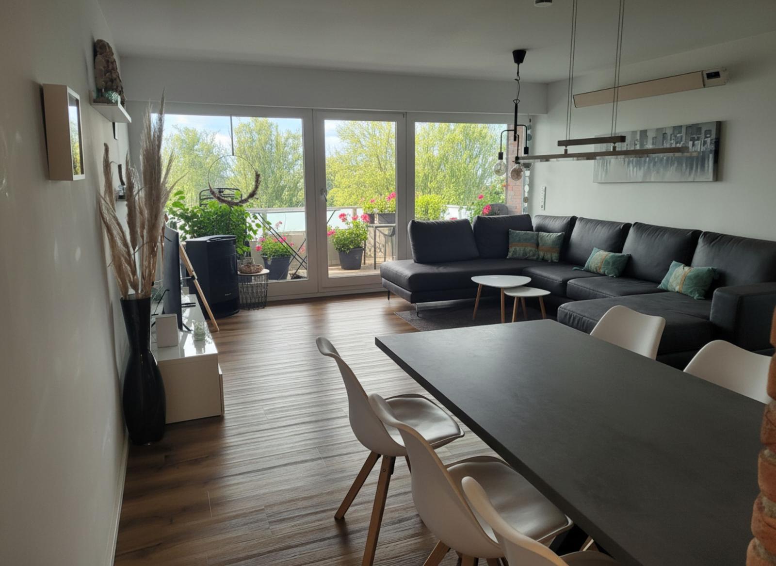 Wohn- und Essbereich mit Balkon, Sofa und Esstisch.