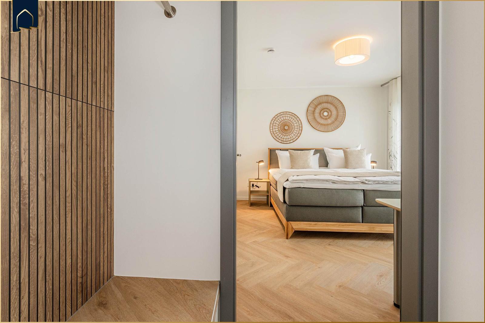 Schlafzimmer mit Bett, Nachttisch und Wanddekoration. Holzfußboden und Holzwandverkleidung.