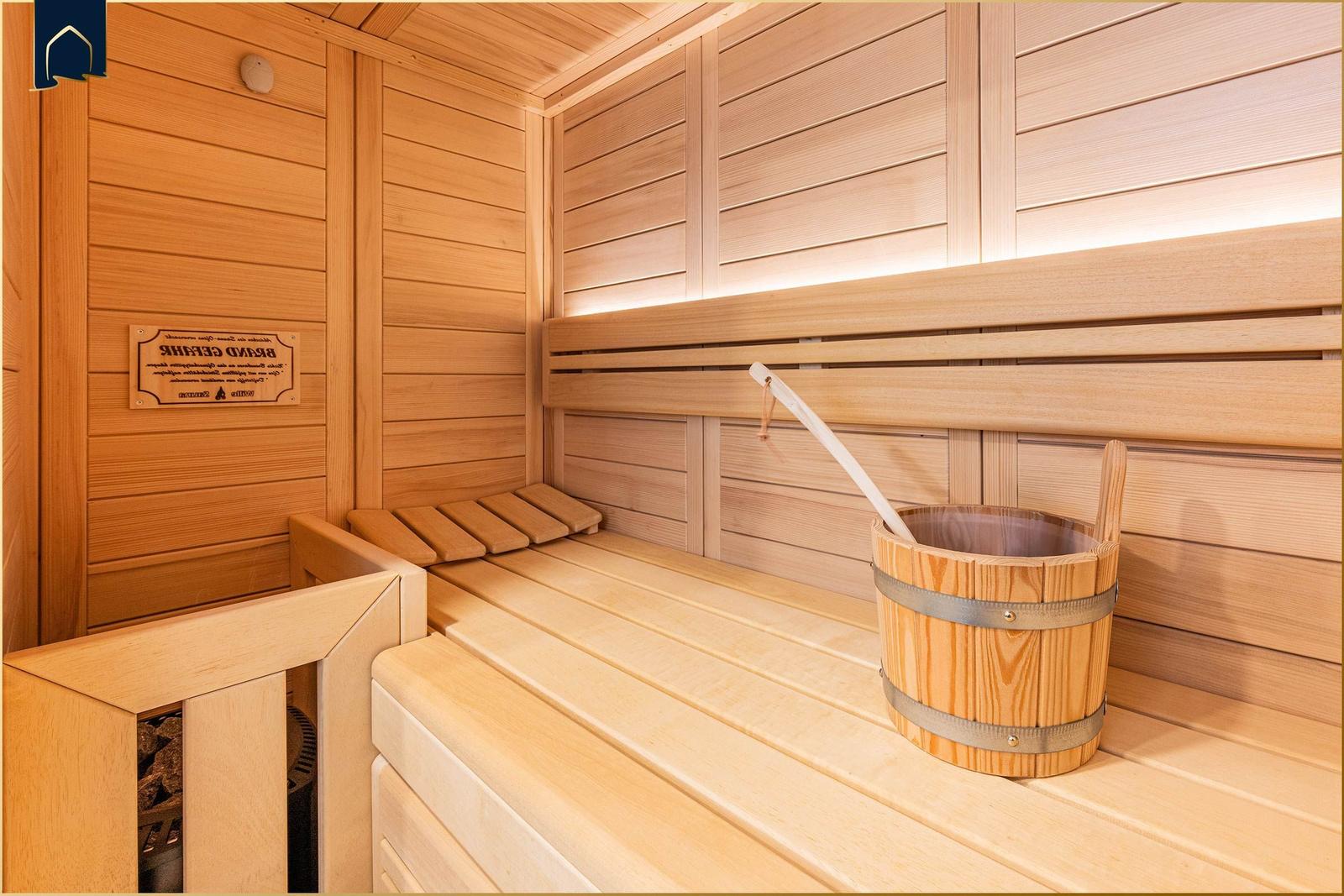 Sauna mit Holzbank, Eimer und Holzwand