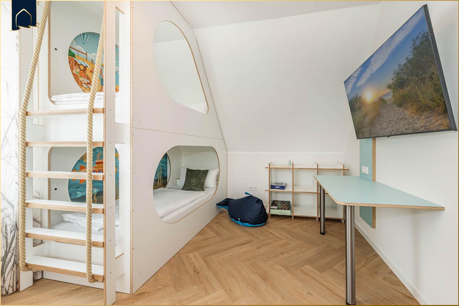 Kinderzimmer mit Kletterturm, Bett und Schreibtisch an der Wand.