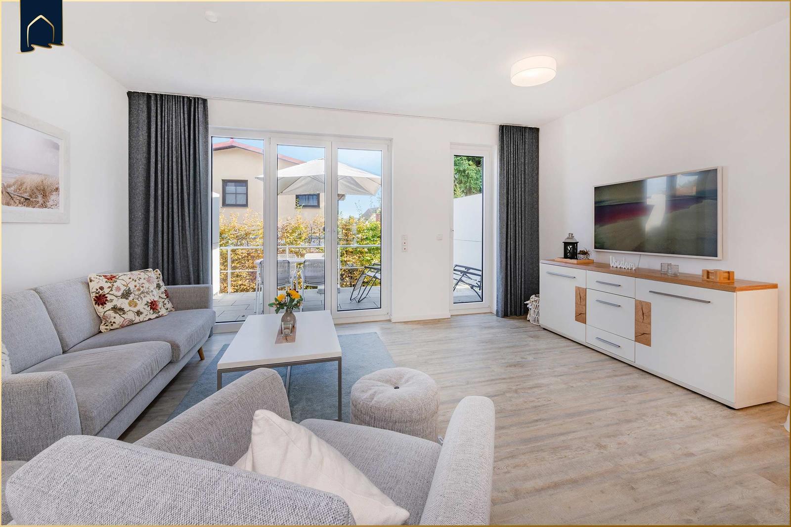 Wohnzimmer mit Sofa, Couch, Fernseher und Terrasse mit Blick.