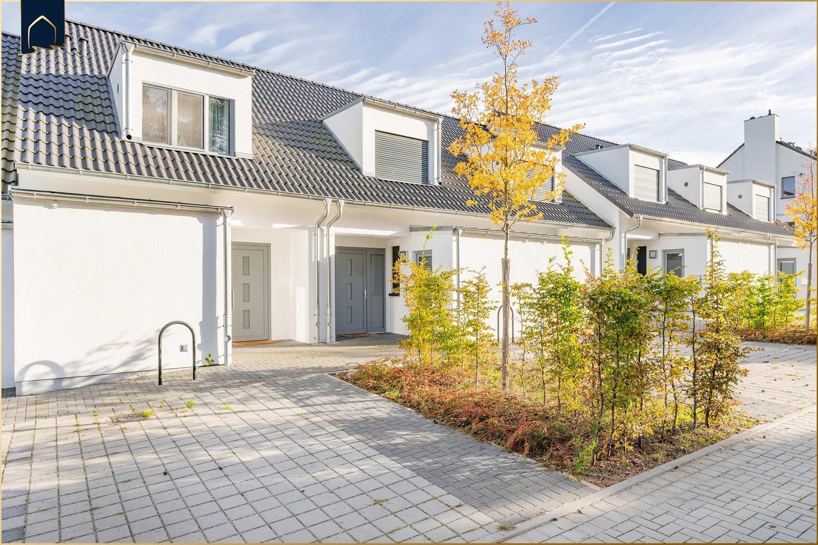 Moderne Reihenhaus mit Terrasse und Gartenbereich im Herbst.