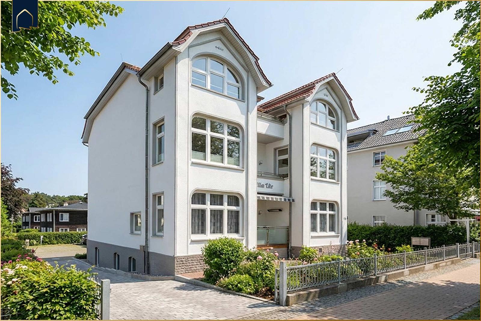 Weiße Villa mit Balkon und gepflegtem Gartenbereich