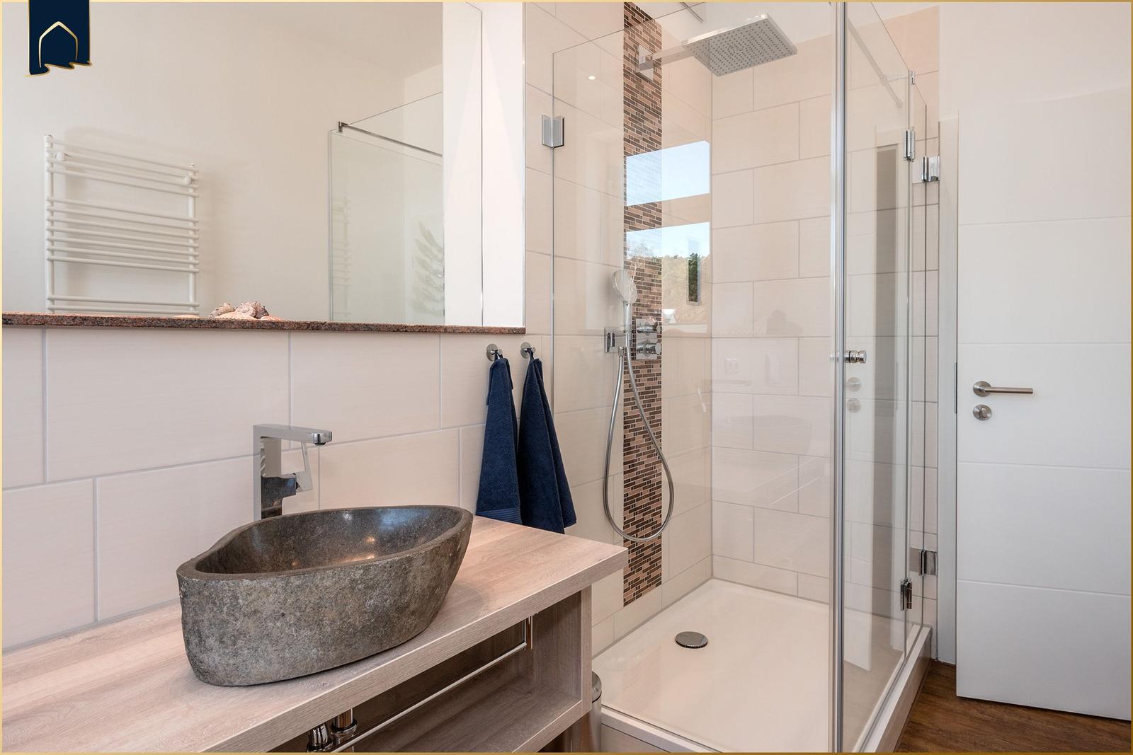 Bad mit Dusche, Waschbecken und Handtuchhalter