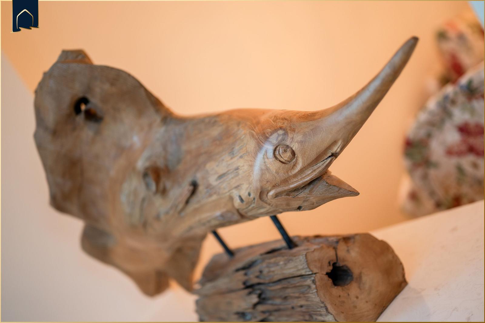 Holzfigur eines Fisches auf einem rustikalen Sockel