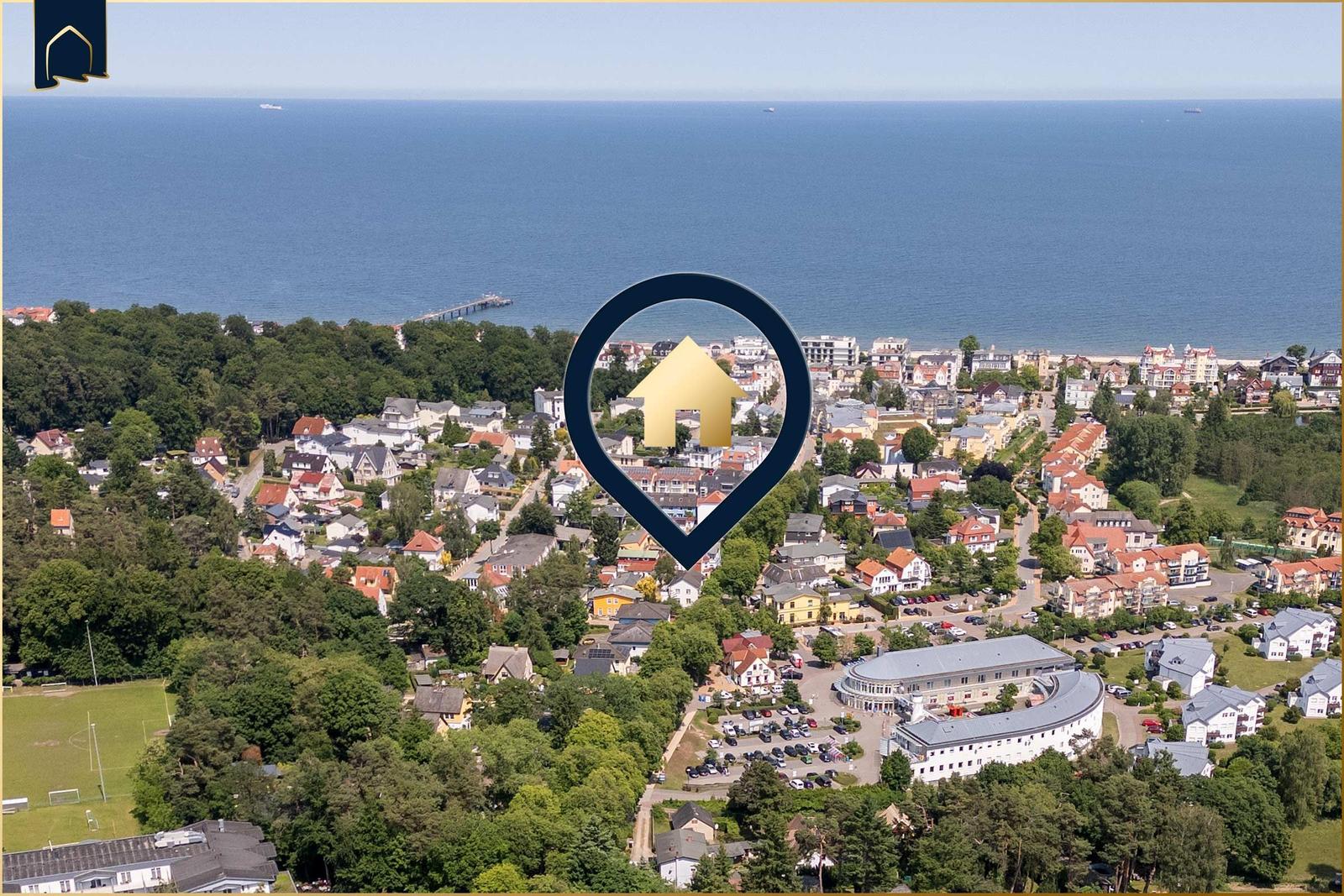 Haus in einer grünen Umgebung mit Blick auf das Meer und einen Hafen.