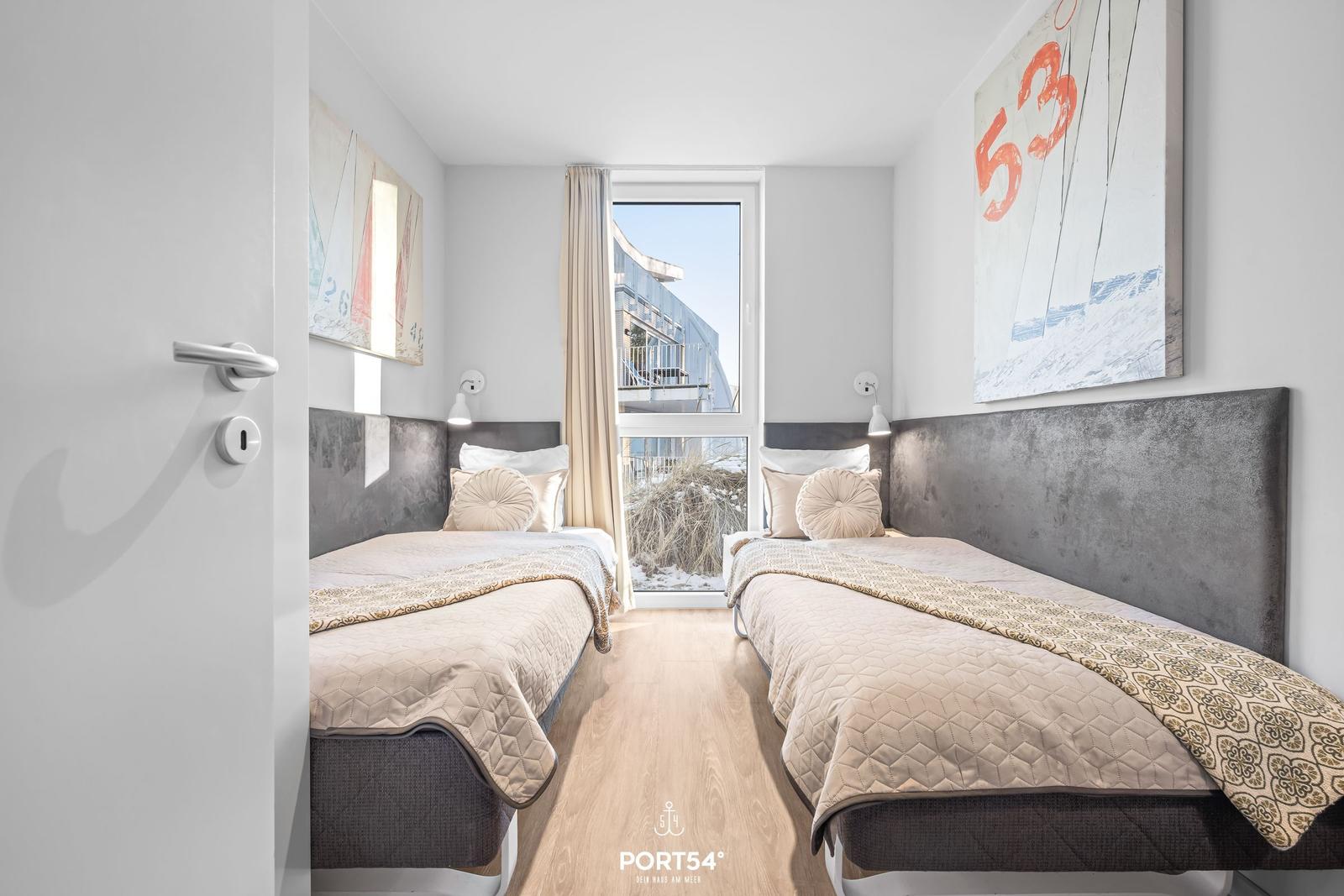 Zwei Betten mit Kopfteil, Wandbild und Fenster mit Blick nach draußen.