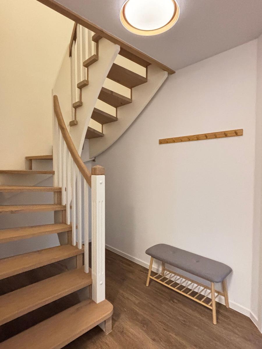 House with staircase, bench, and coat rack on the wall