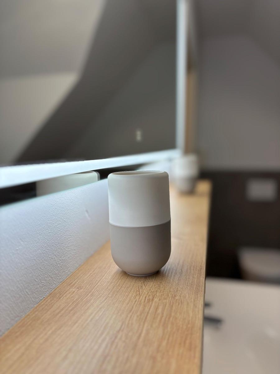 A white-gray fan sits on a wooden surface.