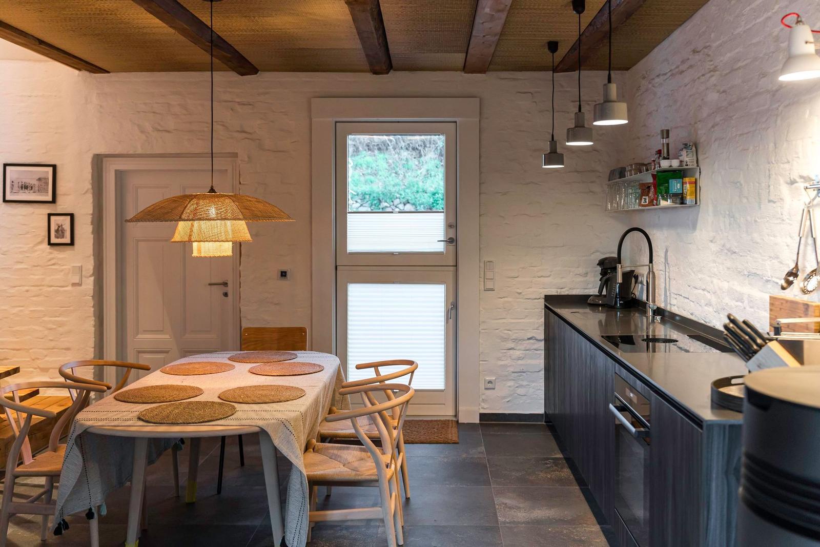 Essbereich mit Tisch und Stühlen, Küche mit Arbeitsplatte und Fenster