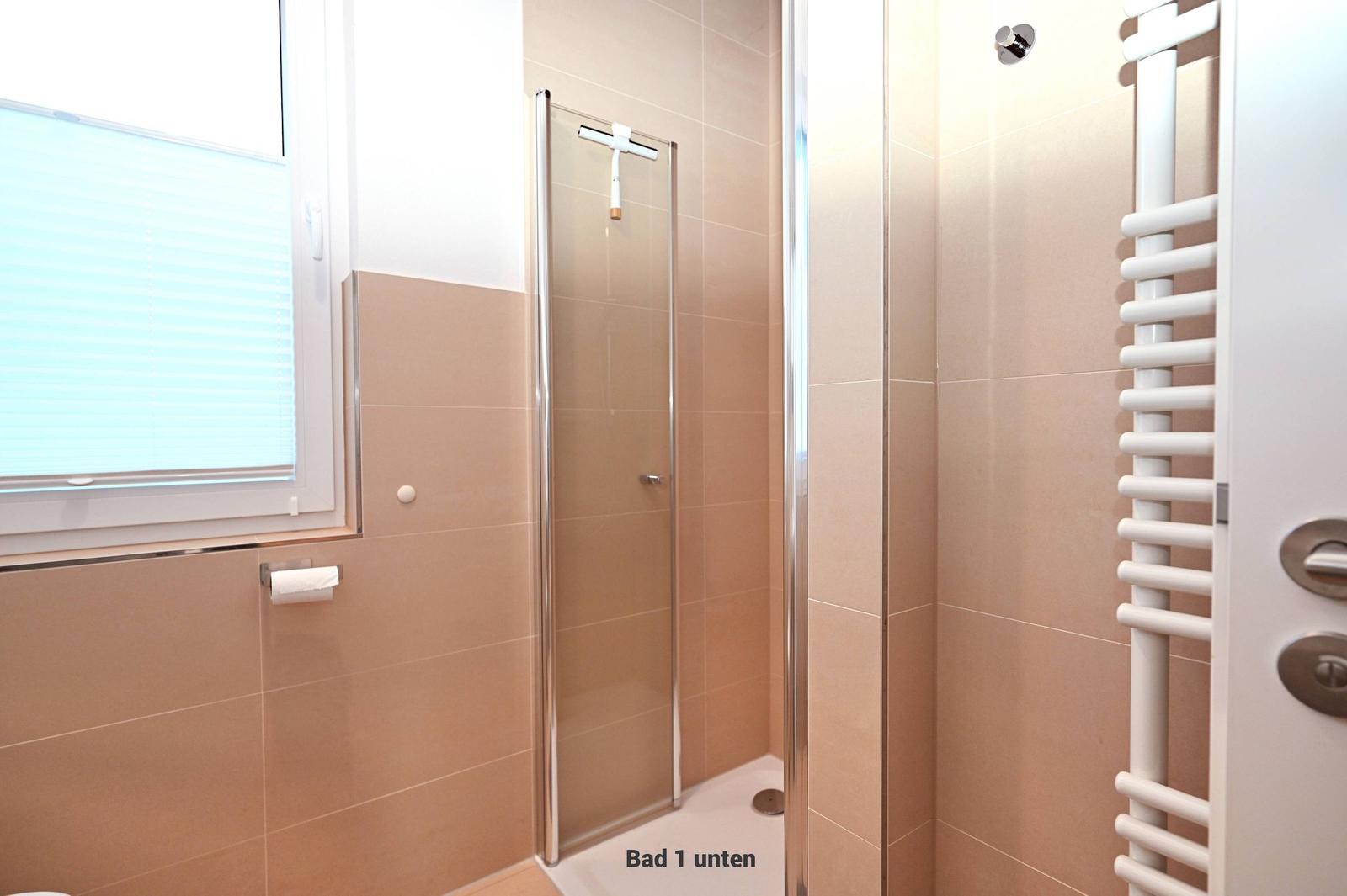 Bad mit Dusche, Fenster und Heizkörper