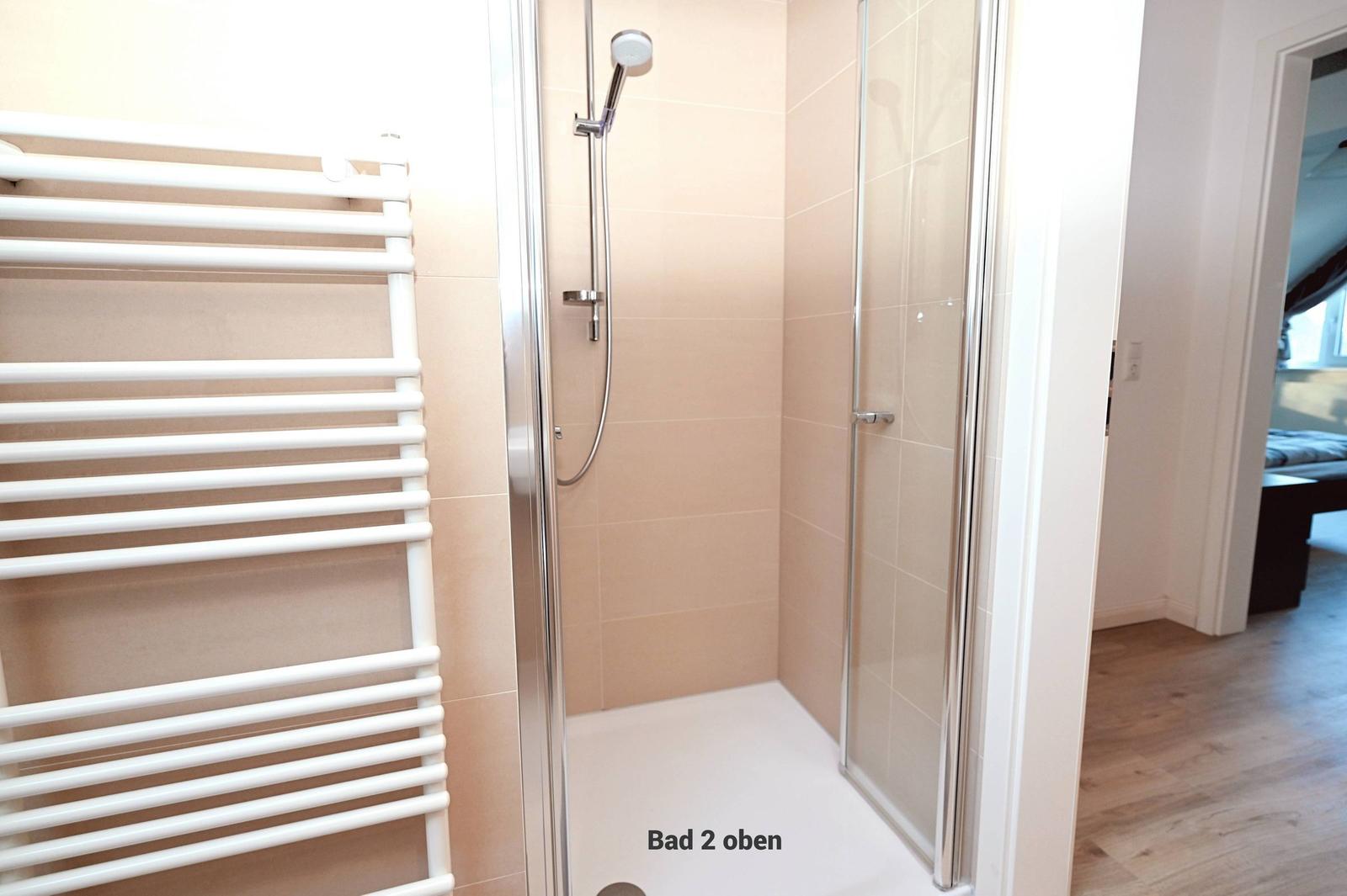 Dusche mit Glaswand und Heizkörper an der Wand