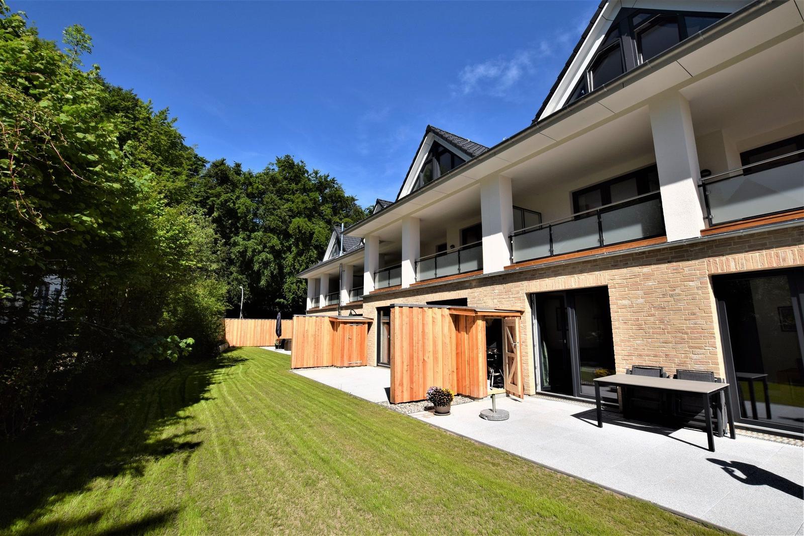 Moderne Villa mit Balkon, Terrasse und Garten. Holzgarage und Sitzgelegenheiten.