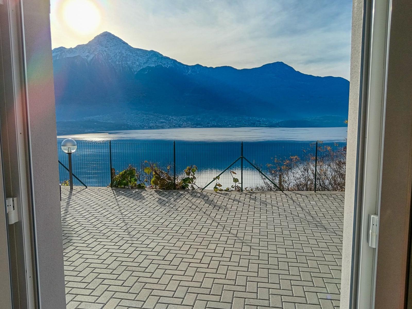 Terrasse mit Blick auf See und schneebedeckte Berge.