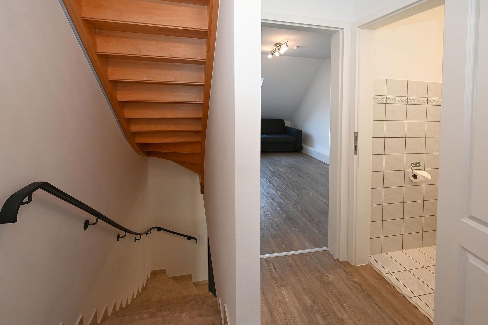 Haus mit Treppe, Wohnzimmer und Bad im Flur.