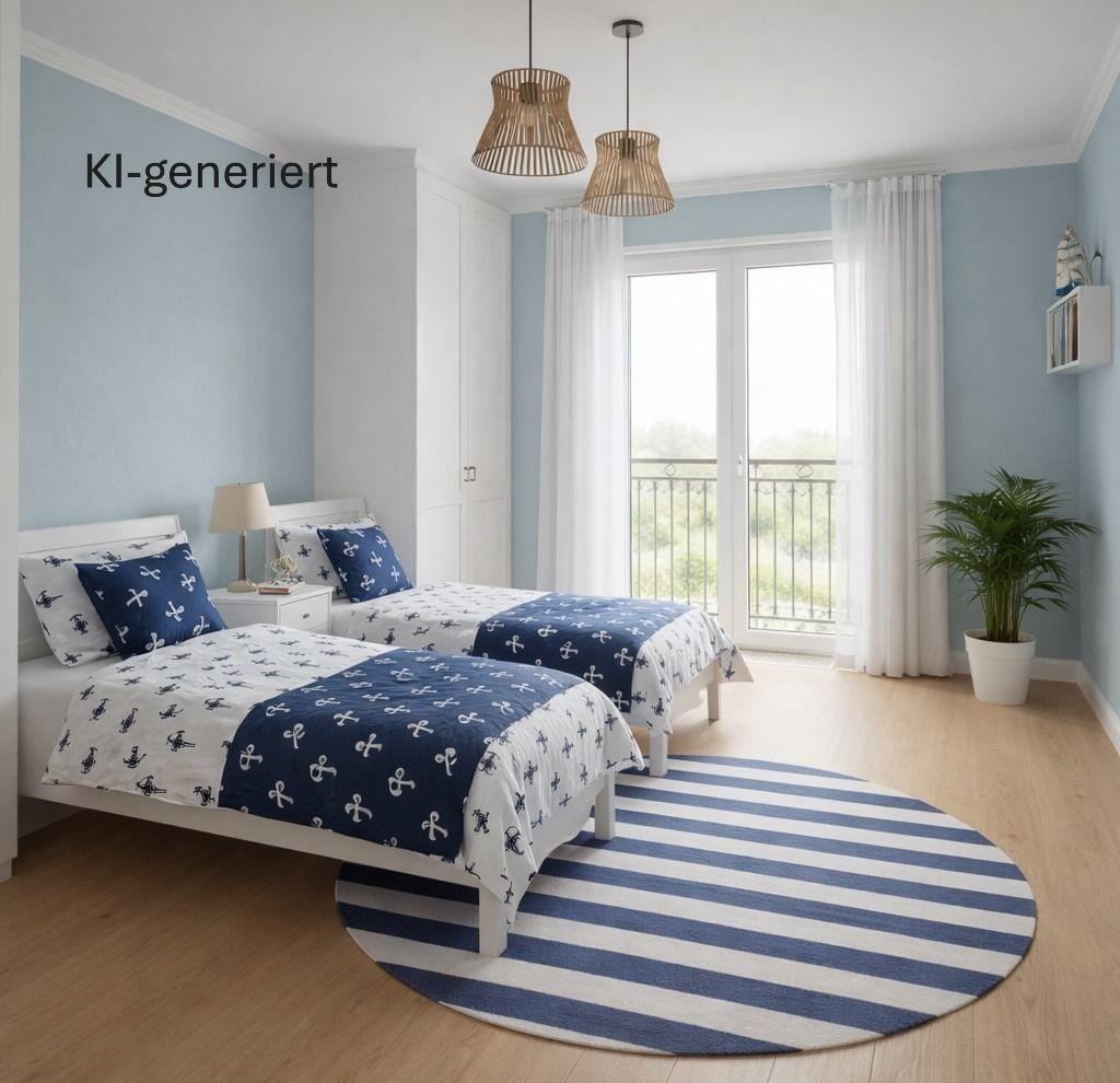 Zwei Betten mit Ankern-Muster, blauer Teppich, Fenster mit Blick auf Balkon.