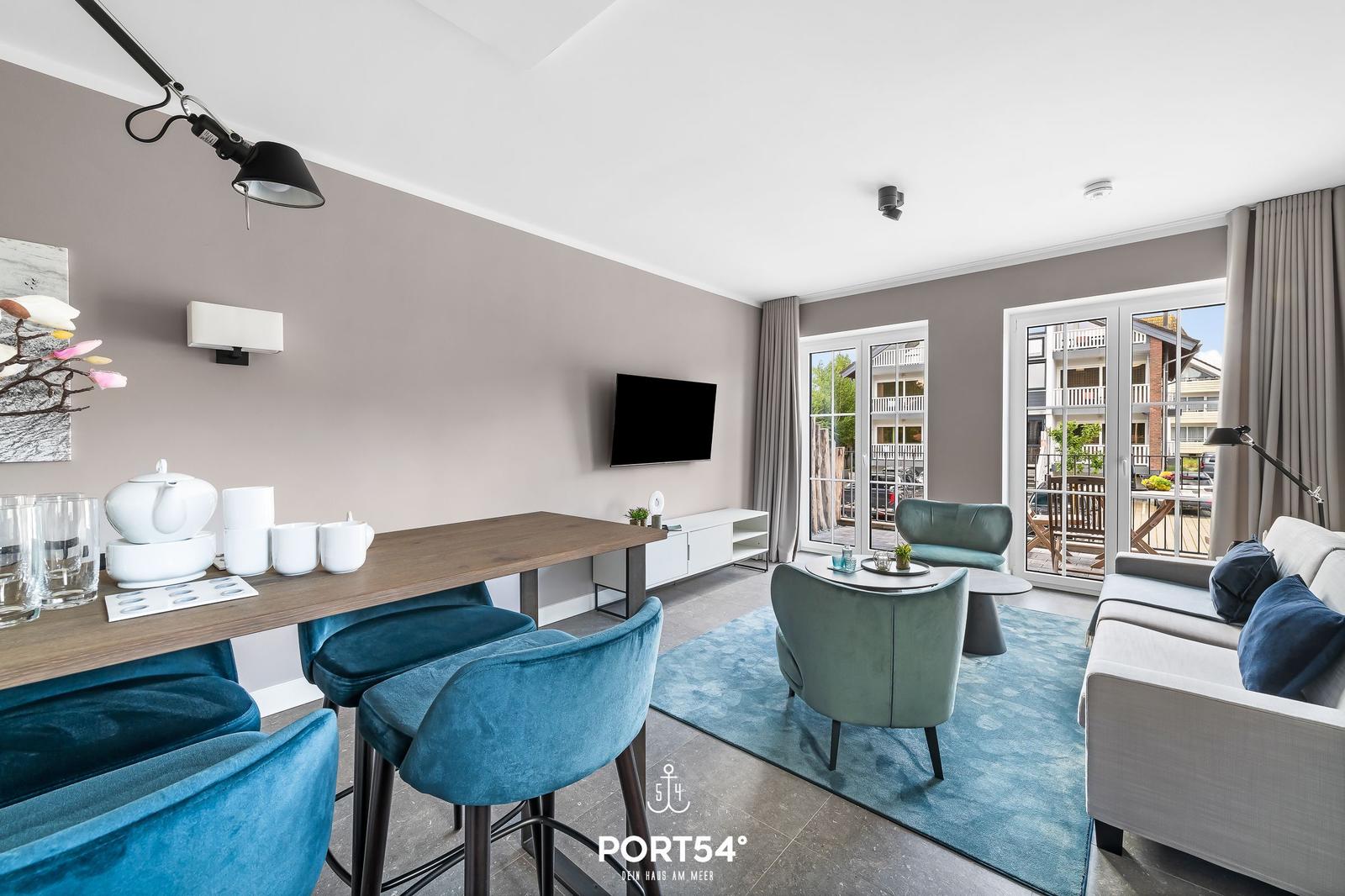 Wohn- und Essbereich mit Sitzgelegenheiten und Blick auf Balkon.