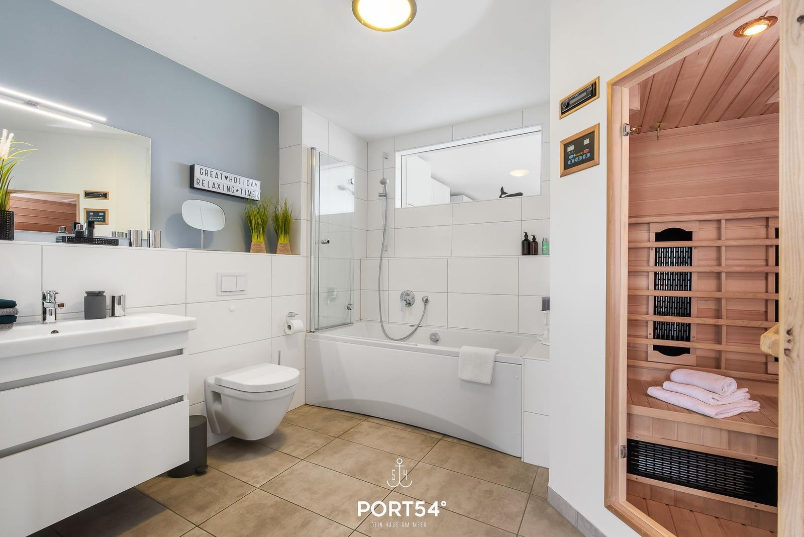 Badezimmer mit Dusche, Badewanne und integrierter Sauna.