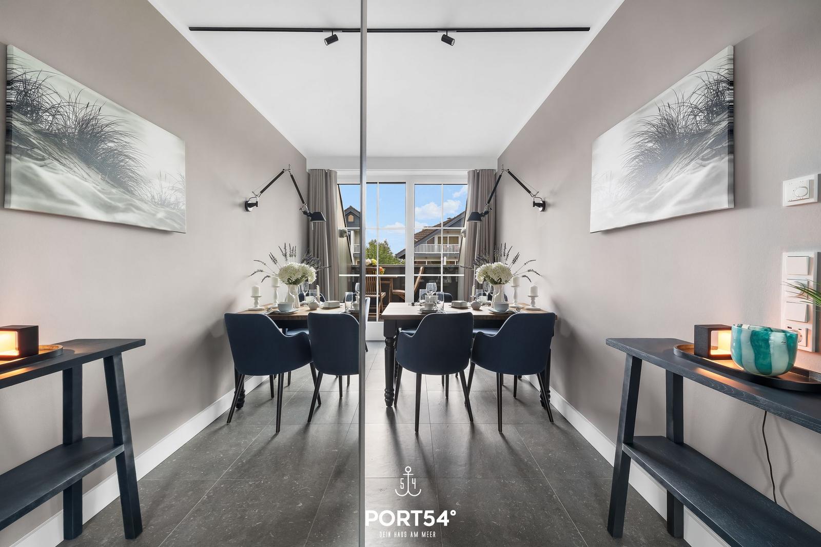 Esszimmer mit Tisch, Stühlen und Fenster zur Terrasse.