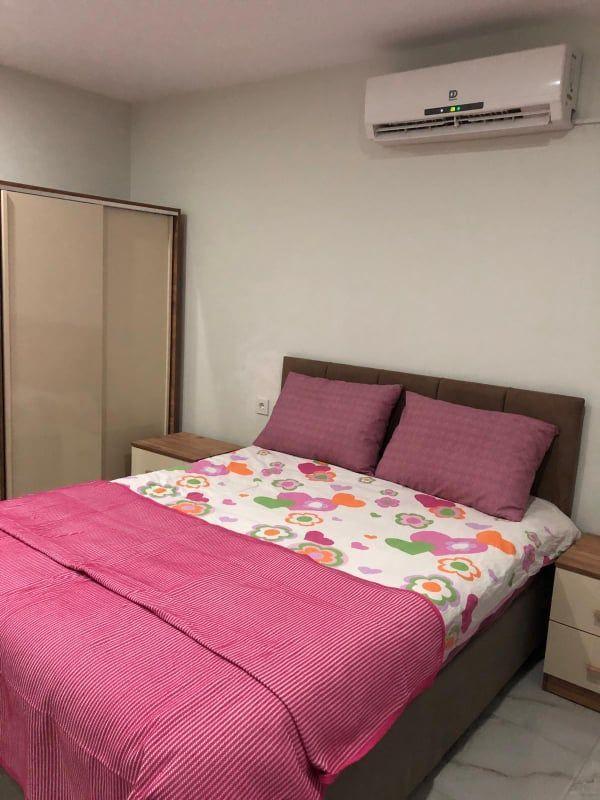 Schlafzimmer mit Bett, Kleiderschrank und Klimaanlage an der Wand.