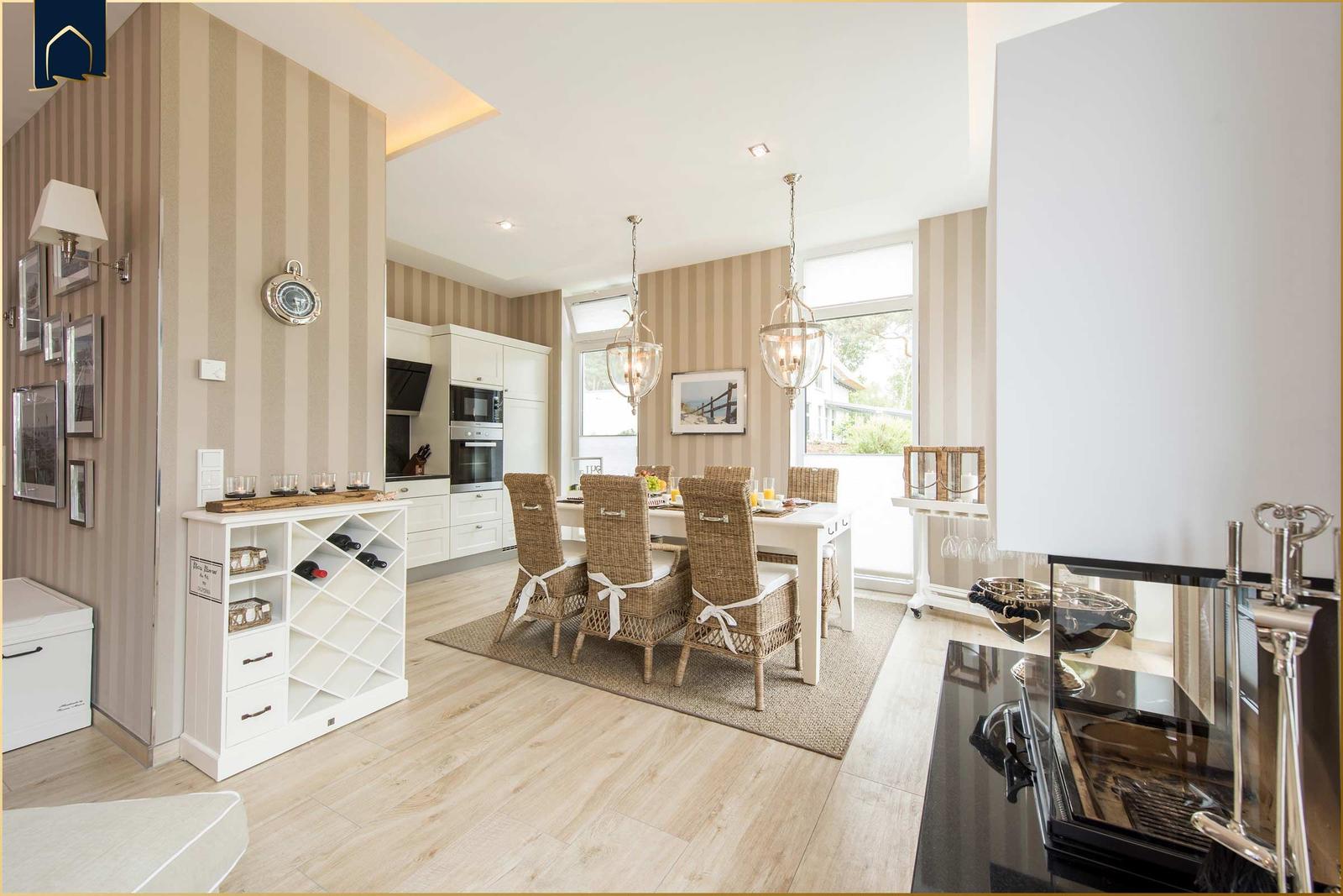 Essbereich mit Esstisch, Stühlen und Küchenbereich. Wand mit Streifen, Holzboden und Fenster.