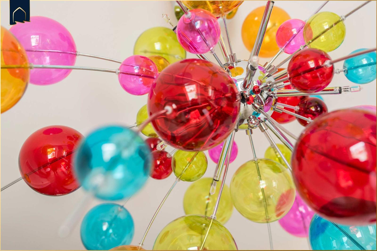 Farbige Glasbälle hängen an Metallstäben an einer Deckenleuchte.