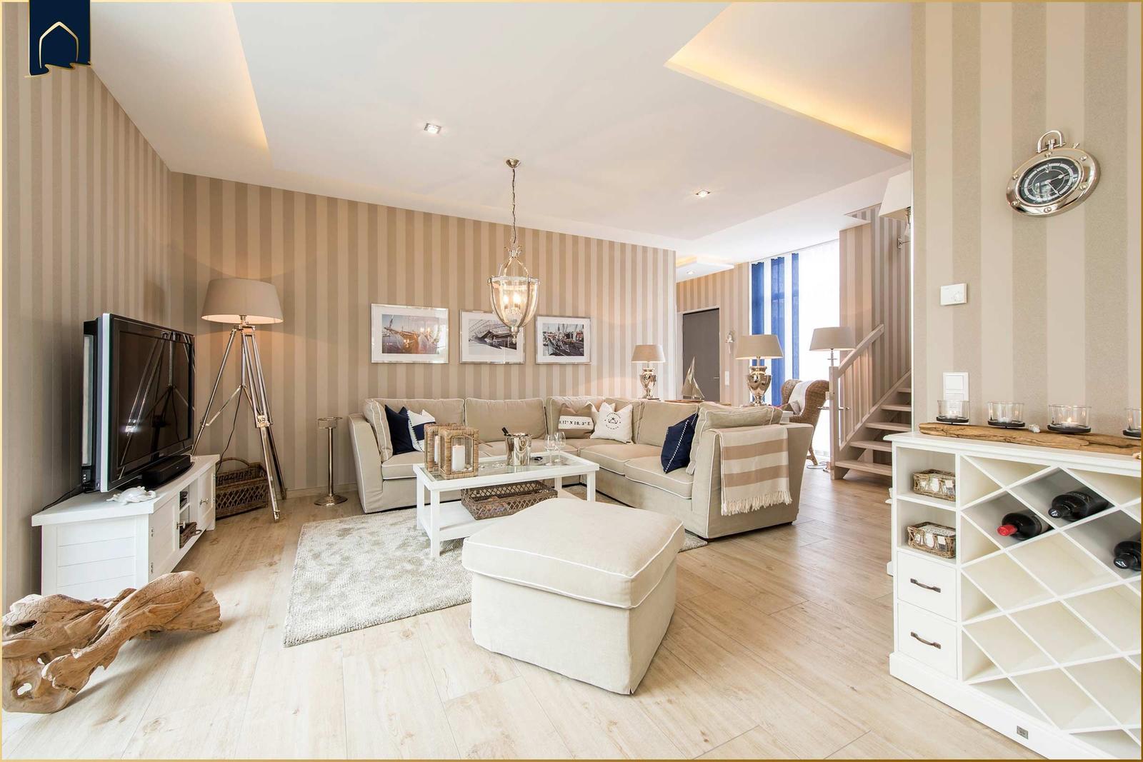 Wohnzimmer mit Sofa, Couchtisch und Fernseher. Wand mit Streifen, Treppenaufgang und Weinkühler.