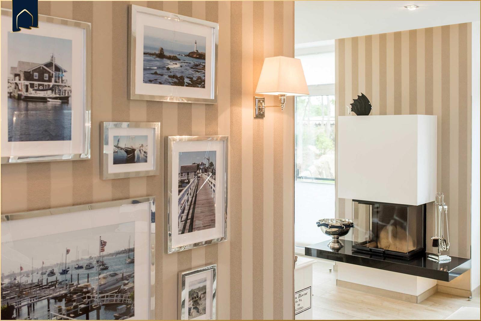 Wand mit gerahmten Bildern und moderner Kaminanlage mit schwarzer Arbeitsplatte.