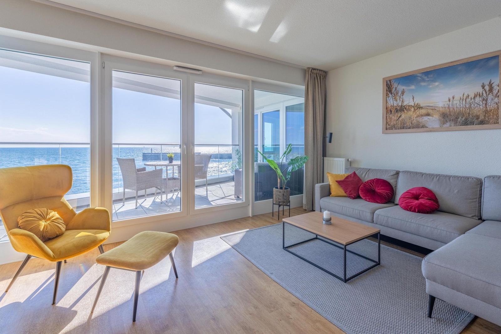 Wohnzimmer mit Blick aufs Meer, Sofa, Sessel und Terrasse.