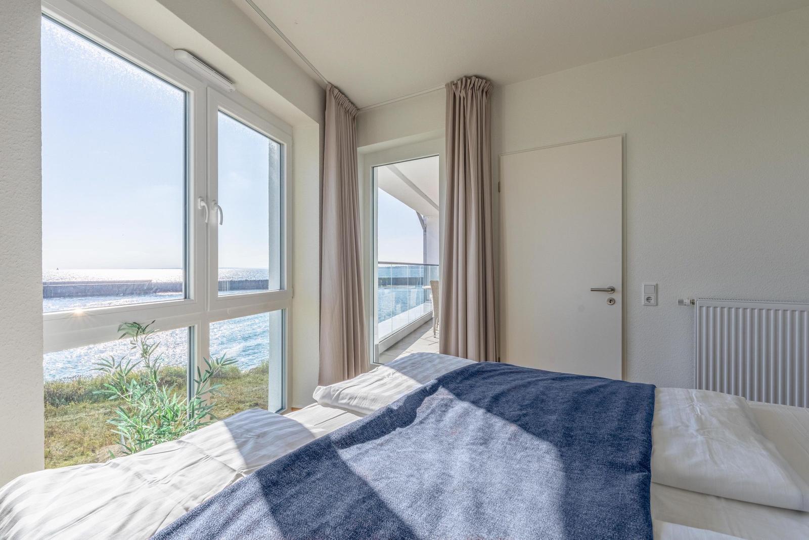 Schlafzimmer mit Blick aufs Meer und Balkonzugang.