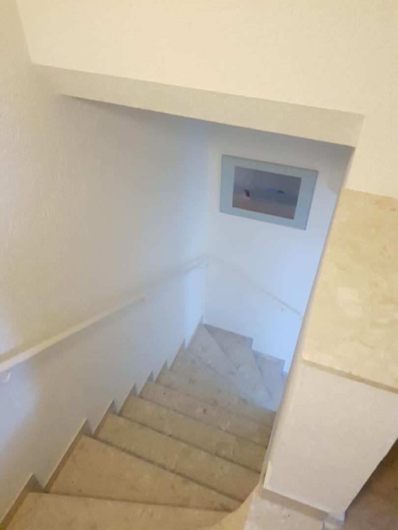 Staircase with handrail and wall picture in hallway