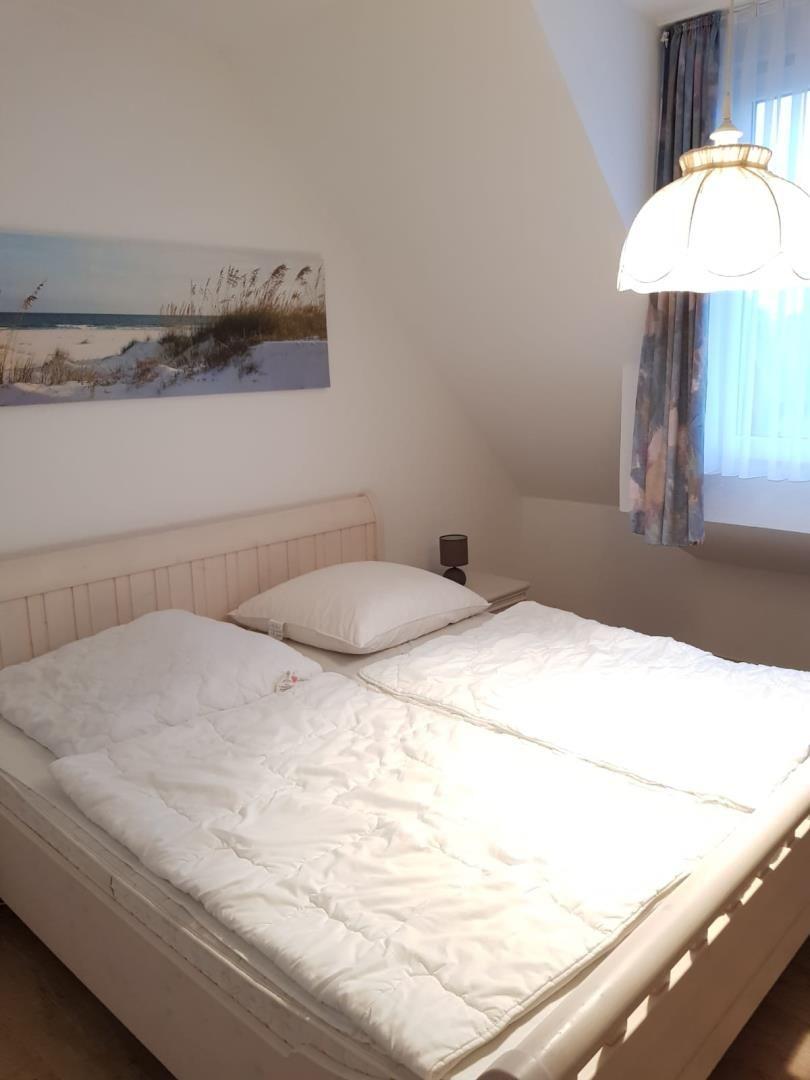 Bedroom with double bed, wall art, and ceiling lamp