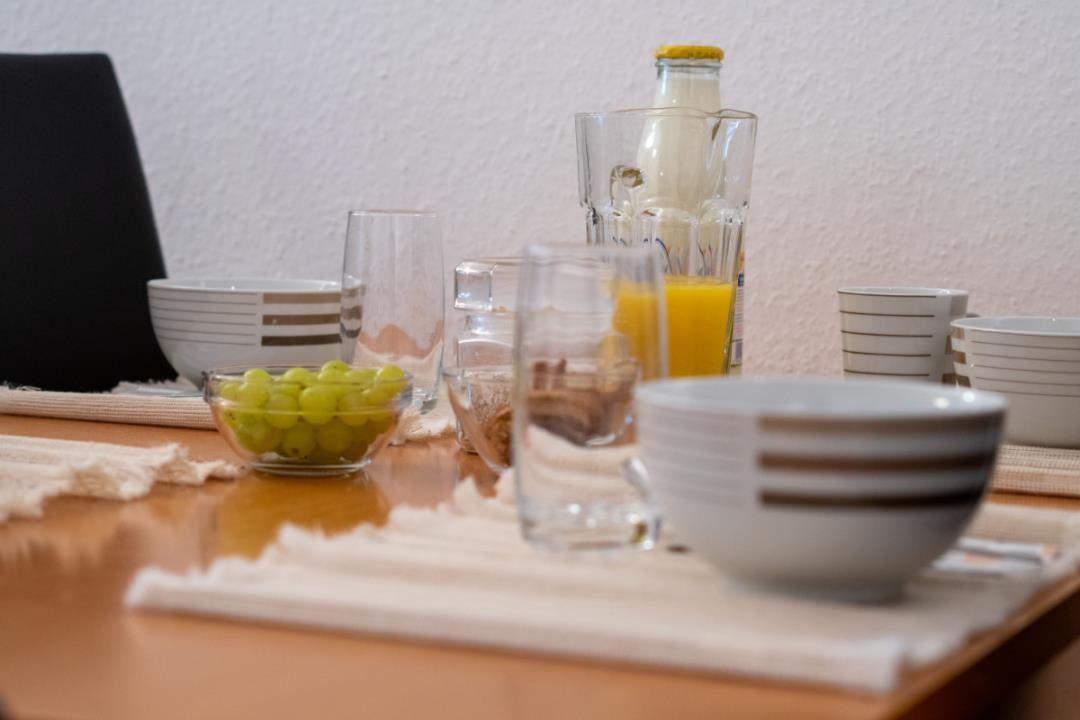 Frühstückstablett mit Gläsern, Schalen und einer Flasche Milch.