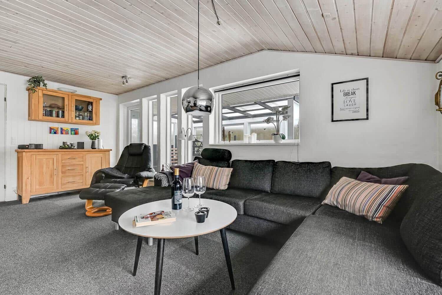 Living room with gray sofa, wooden furniture, and ceiling fan.