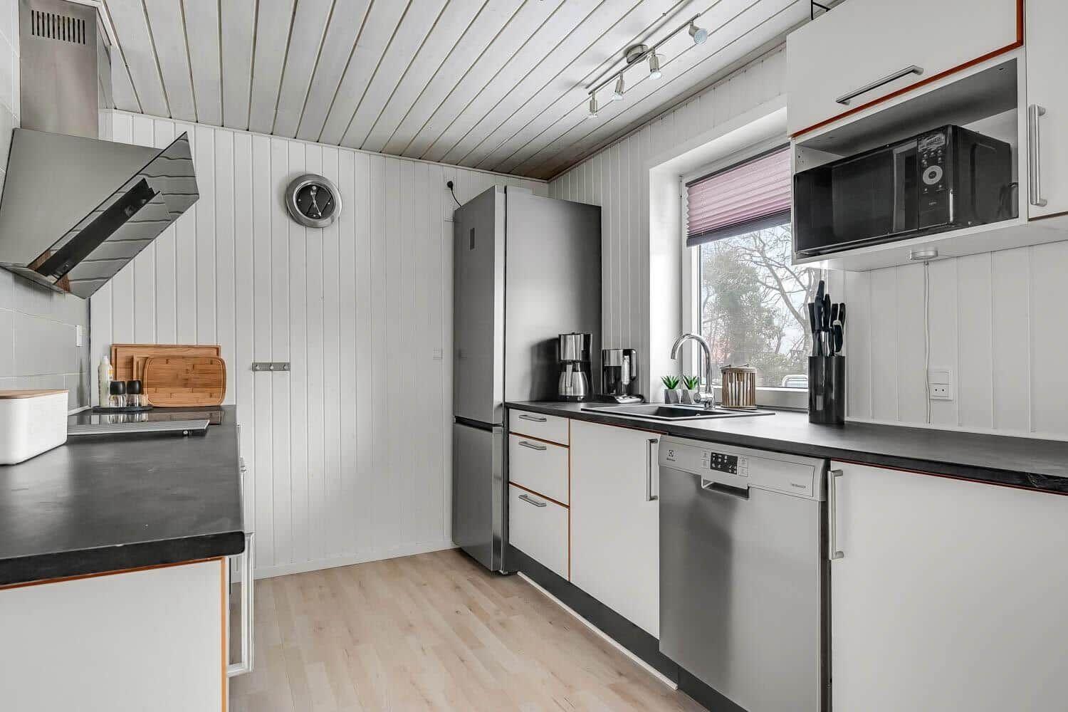 Kitchen with white cabinets, stainless steel appliances, and wooden floor.