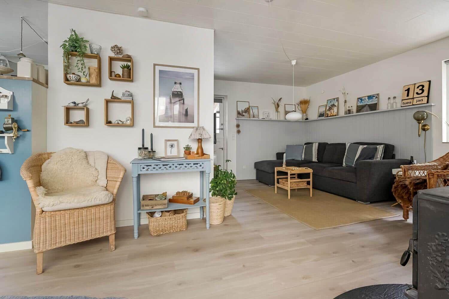 Wohnzimmer mit Sofa, Sitzgelegenheit und Wandregal mit Dekoration.