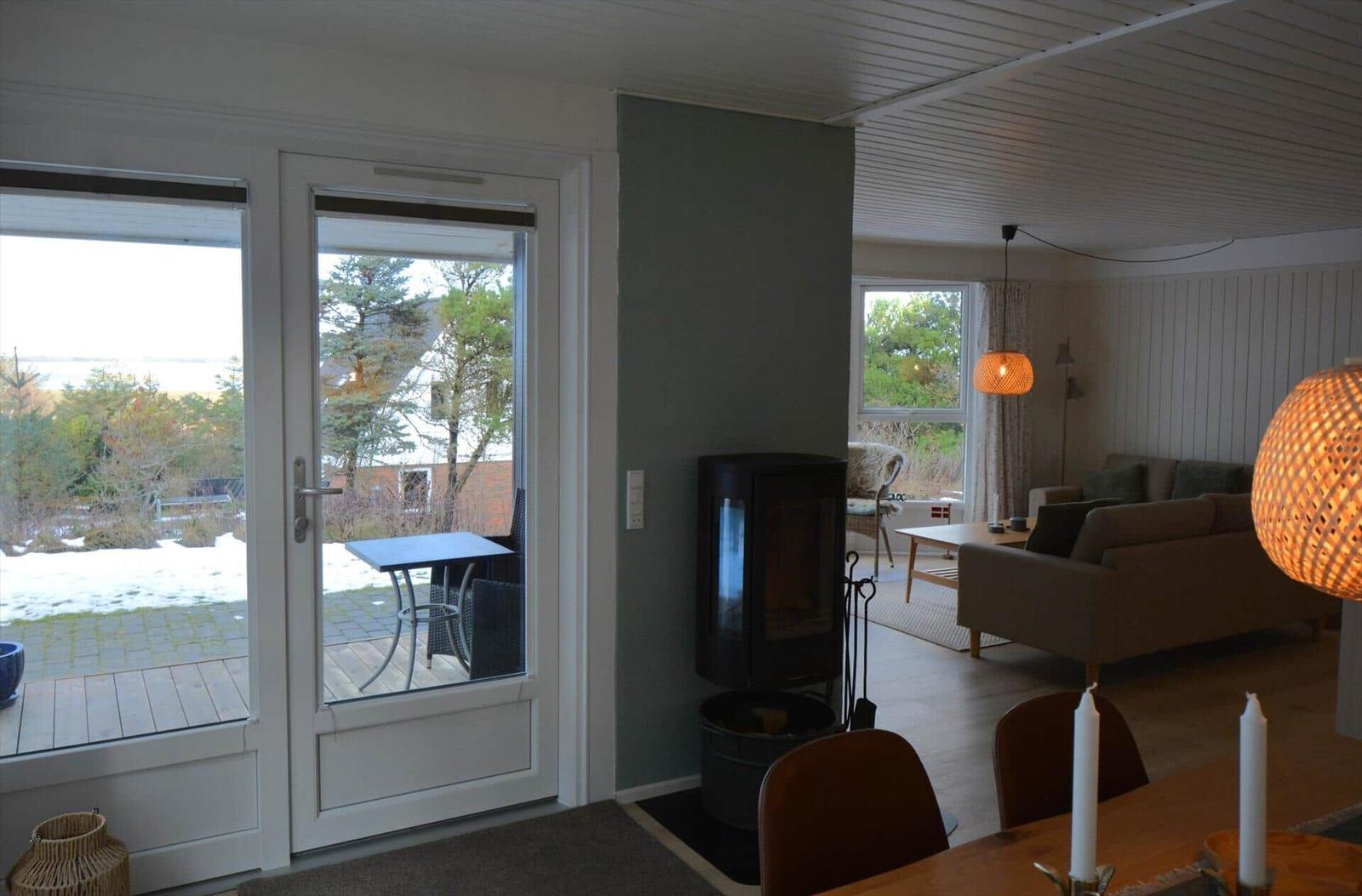 Wohnung mit Blick auf Garten, Kamin und Wohnbereich mit Sofa und Tisch.