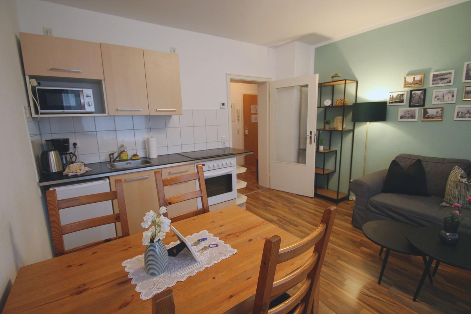 Küche mit Essbereich und Wohnzimmer mit Sofa und Tisch.