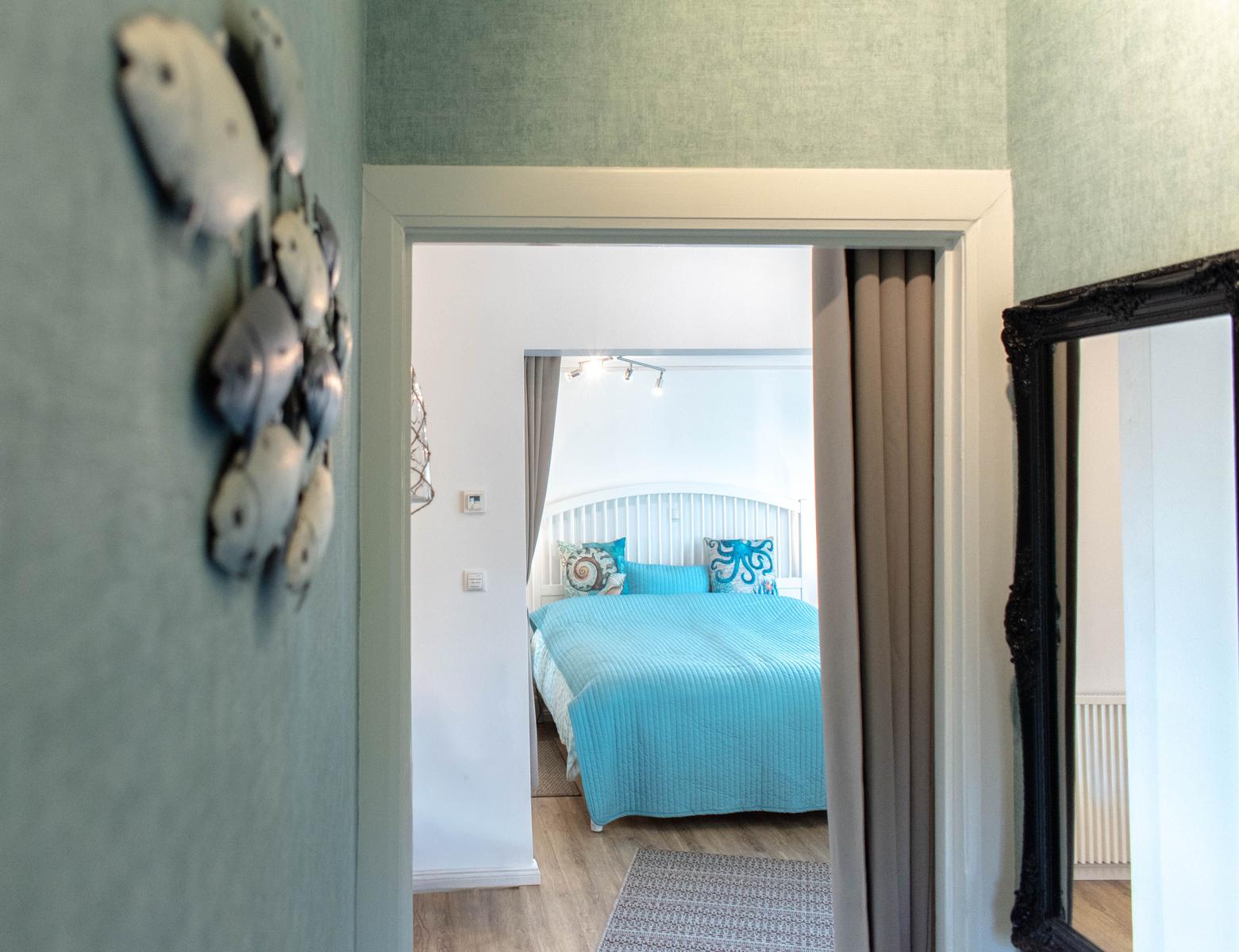Durchgang in Schlafzimmer mit blauem Bett und Wanddekoration