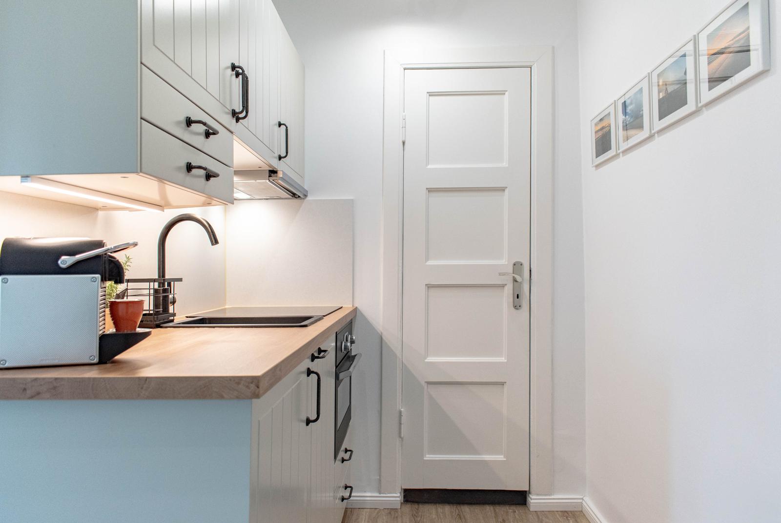 Küche mit Arbeitsplatte, Spüle und Tür