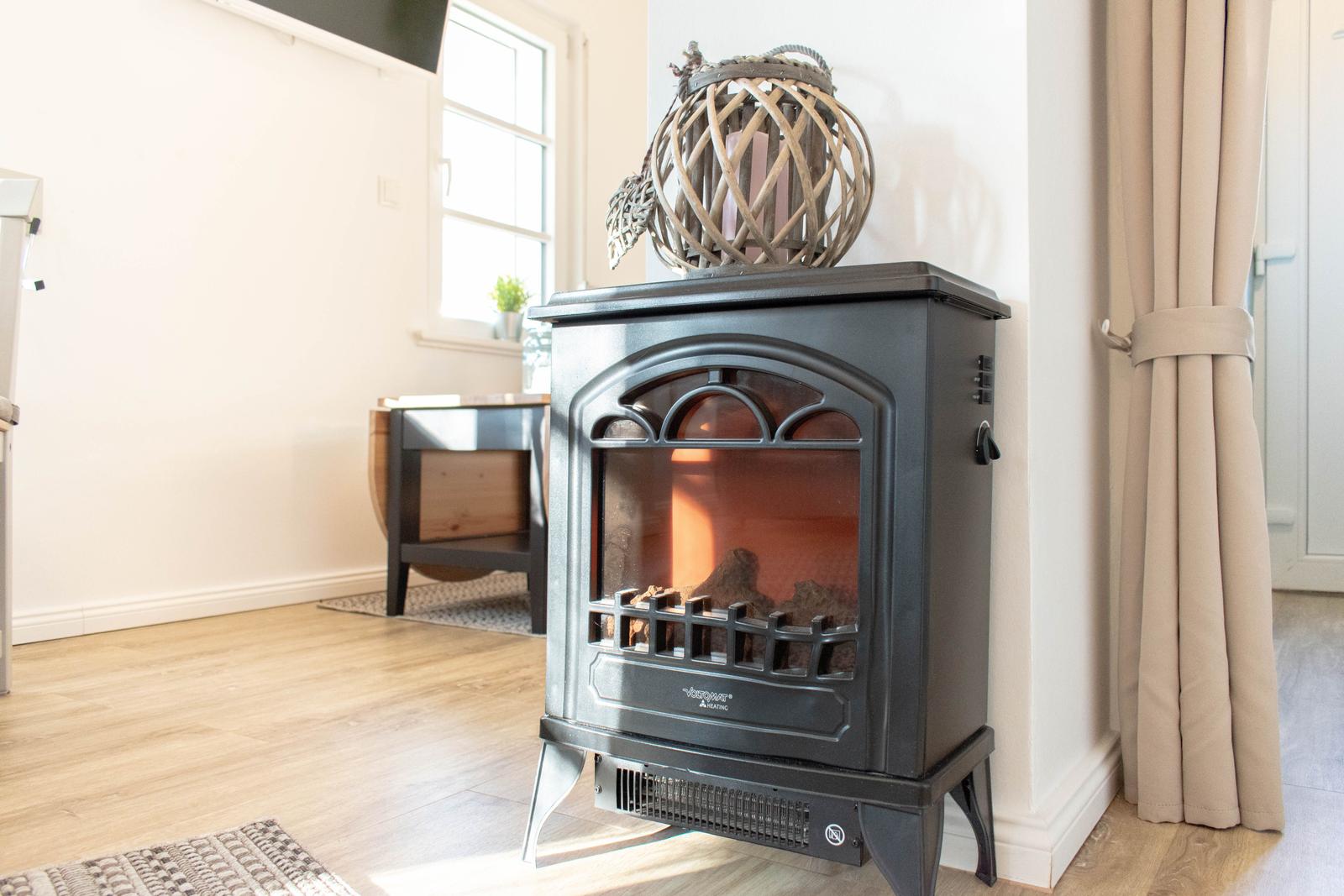 Eine Heizung mit Kamin und dekorativer Laterne auf einem Holzboden.