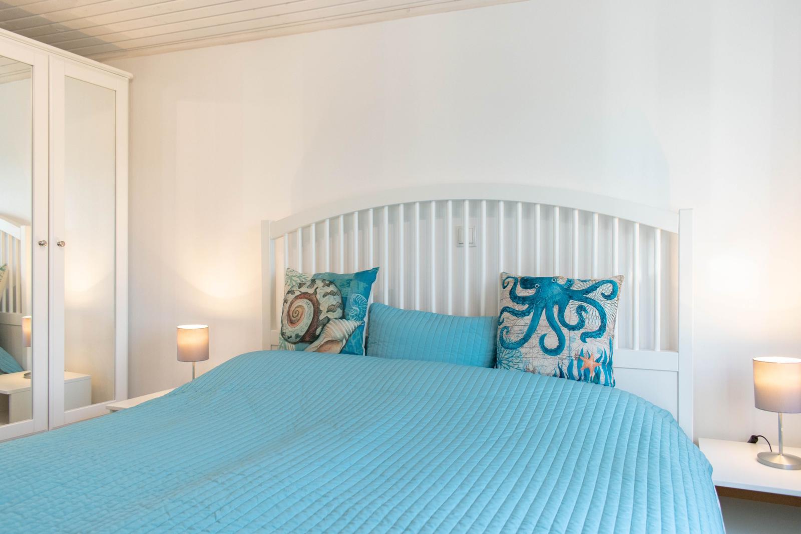 Schlafzimmer mit Bett, zwei Nachttischen und einem Kleiderschrank.