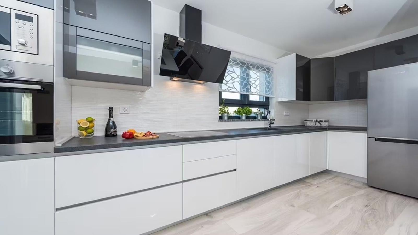Modern kitchen with stainless steel appliances and dark countertops.