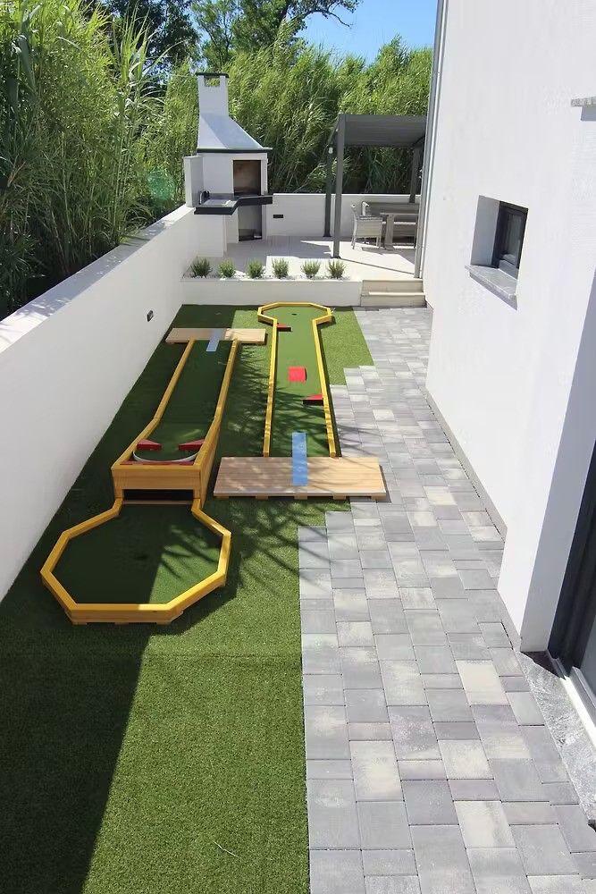 Backyard with mini golf, grill, and seating area.